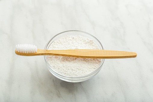 Bamboo toothbrush, dentifrice tooth powder on white marble background. Biodegradable natural bamboo toothbrush. Eco friendly, Zero waste, Dental care Plastic free concept
